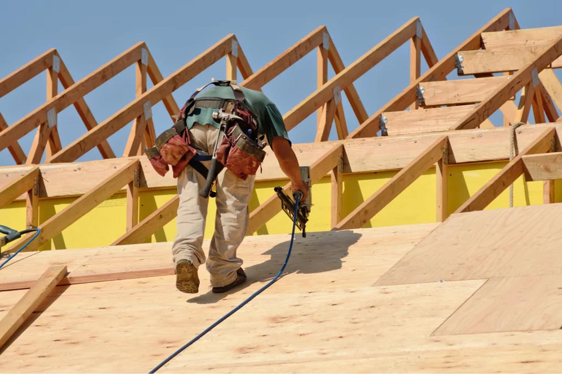 Contractor replacing damaged plywood roof decking and sheathing during a Miami roof replacement