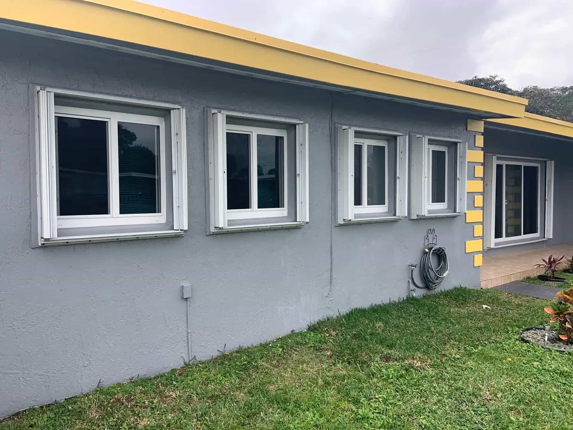 Miami home exterior with modern impact windows replacing older aluminum windows