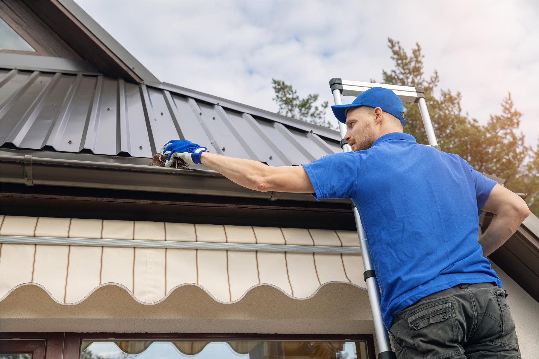 Homeowner performing roof maintenance and gutter cleaning on a Miami residential home
