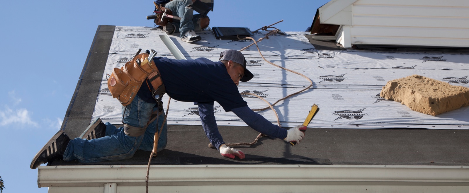 Roofing crew installing new shingles during a Miami roof replacement project